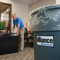 Alliance Maintenance Employee emptying trash cans and replacing liners