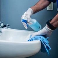 Alliance Maintenance worker cleaning the bathroom with disinfectant